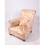 AN EARLY 20TH CENTURY ARMCHAIR with scroll arms, upholstered with pink flower decorated material and
