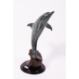 A CONTEMPORARY BRONZE SCULPTURE depicting a leaping dolphin on an ebonised plinth, 56cm high