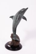 A CONTEMPORARY BRONZE SCULPTURE depicting a leaping dolphin on an ebonised plinth, 56cm high