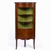AN EDWARDIAN MAHOGANY SERPENTINE FRONTED CORNER FLOOR STANDING DISPLAY CABINET with green silk lined