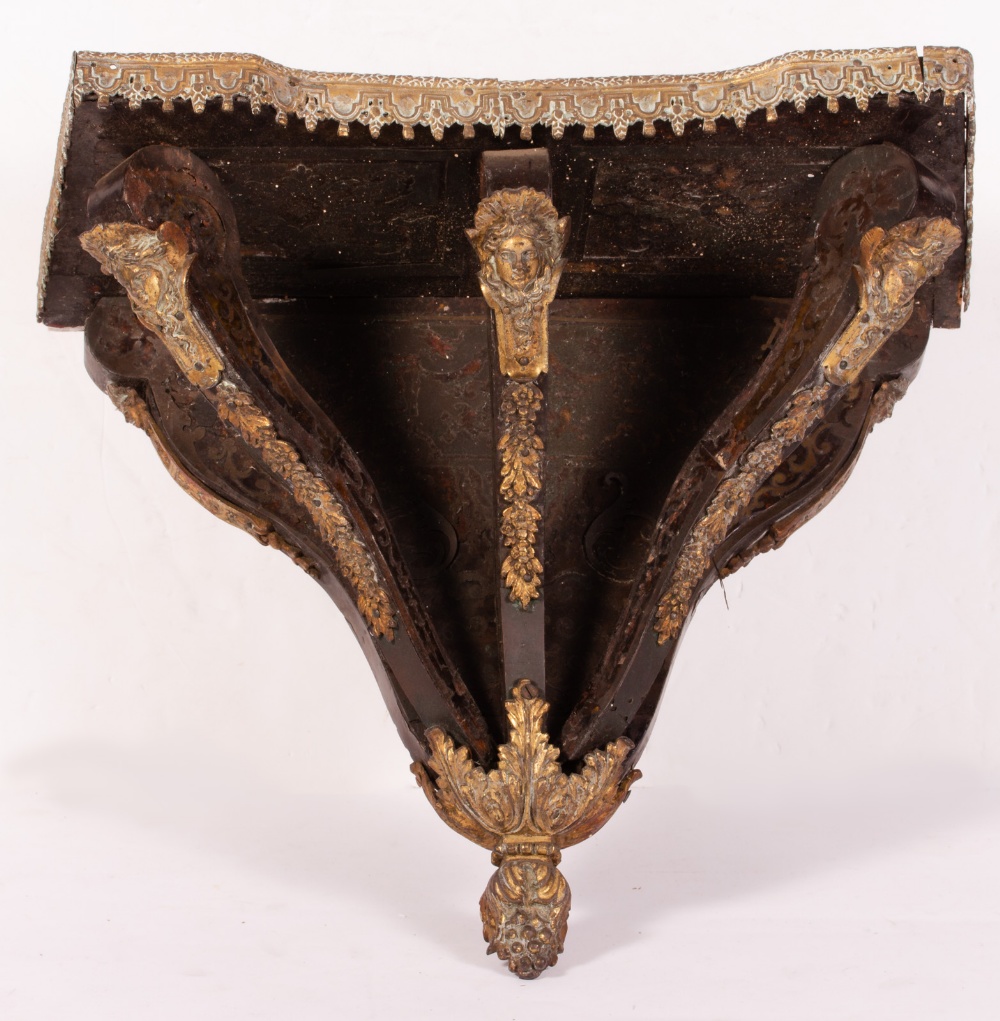 A 19TH CENTURY BOULLE STYLE BRACKET with cast ornament including masks, 42cm wide x 23cm deep x 40cm