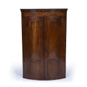 A GEORGE III MAHOGANY HANGING BOW FRONTED CORNER CUPBOARD with panelled door, decorative marquetry