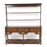 A 19TH CENTURY OAK DRESSER with plate rack above, the base with three large drawers, two smaller