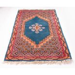 A PERSIAN STYLE TURQUOISE AND ORANGE GROUND WOOLLEN RUG with geometric decoration, 104cm x 194cm