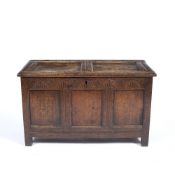 AN ANTIQUE OAK COFFER with panelled top and triple panelled front with later chip carved decoration,