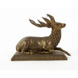 A 19TH CENTURY GILT BRASS SCULPTURE OF A RESTING STAG on a rectangular plinth base, 13.5cm wide x