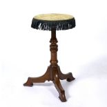 A HOWARD & SONS BERNERS STREET ROSEWOOD GYPSY TABLE with a turned support and triform base,