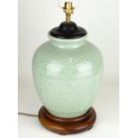 A MODERN OVOID CELADON GLAZED TABLE LAMP with turned wooden base and moulded decoration, 23cm