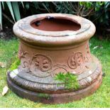 A CAST TERRACOTTA URN STAND of spreading circular form, decorated with masks, 50cm diameter x 33cm