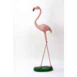 A CAST COMPOSITE AND PAINTED SCULPTURE OF A FLAMINGO standing on a green oval plinth base, 100cm