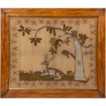 A WILLIAM IV WOOLWORK PICTURE depicting a reclining stag beneath a tree, within a floral border,