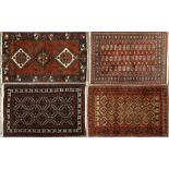 A MIDDLE EASTERN RED AND BLACK GROUND RUG with geometric decoration, 120cm x 198cm together with