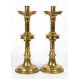 A PAIR OF VICTORIAN GOTHIC STYLE BRASS CANDLESTICKS with knopped stems and spreading bases, 13.5cm