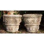 A PAIR OF COMPOSITE STONE URNS decorated with acanthus leaves and face masks, each 54cm diameter x