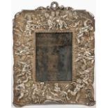 AN OLD SILVER PLATED PHOTOGRAPH FRAME decorated with putti and garlands of flowers around the