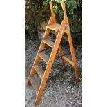 AN OLD STEP LADDER with fluted treads and iron hinge, 93cm front to back x 136cm high when open