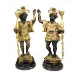 A PAIR OF CAST BRONZE FIGURES in the form of Turkish torch bearers, each mounted on a circular