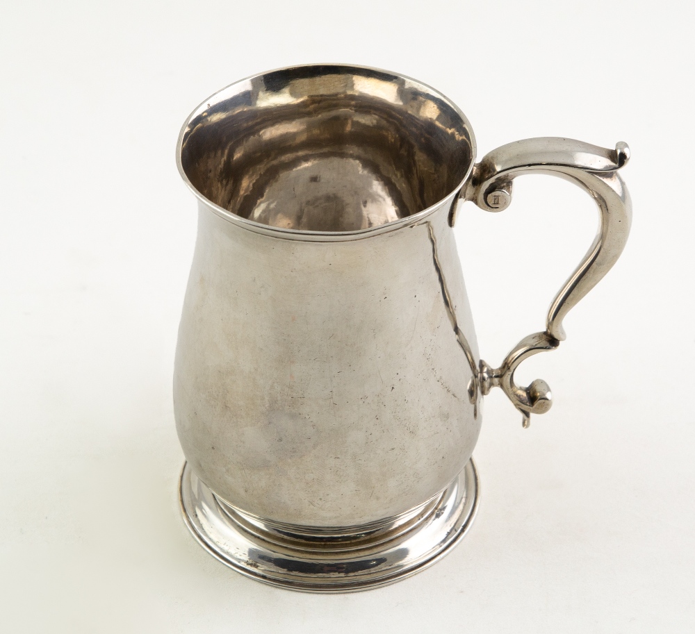 A GEORGE III SILVER BALUSTER PINT TANKARD with scrolling handle, stepped circular base, with