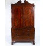 A 19TH CENTURY MAHOGANY LINEN PRESS with twin panelled doors above two short and two long drawers