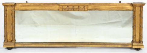 A LATE 19TH CENTURY GILDED OVERMANTLE MIRROR with reeded pilaster column sides, 151cm wide x 49cm