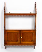 A VICTORIAN MAHOGANY HANGING WALL SHELF with twin panelled cupboard door, 52.4cm wide x 13cm deep