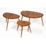 AN ERCOL LIGHT ELM NEST OF THREE OCCASIONAL TABLES with turned legs, the largest 64cm wide x 43cm