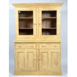 A CREAM PAINTED PINE CUPBOARD with twin glazed doors above two short and two panelled doors,