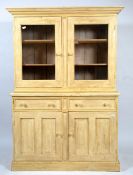 A CREAM PAINTED PINE CUPBOARD with twin glazed doors above two short and two panelled doors,