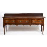 A GEORGE III OAK DRESSER the three drawers with mahogany crossbanded decoration with a shaped frieze