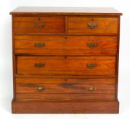 AN EDWARDIAN WALNUT CHEST OF TWO SHORT AND THREE LONG DRAWERS with brass handles and raised on a