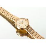 A MID 20TH CENTURY LADIES OMEGA 9 CARAT GOLD COCKTAIL WATCH with a 9 carat gold bracelet strap,