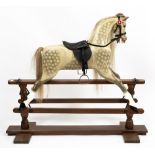 AN EARLY TO MID 20TH CENTURY PAINTED WOODEN ROCKING HORSE on a stained pine frame, overall 140cm