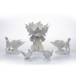 Five white glazed continental figure groups possibly by Nymphenburg, one a centre piece of seahorses