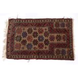 Pakistan rust ground rug with stylised medallions, 146cm x 89cm Condition: fraying to the edge and