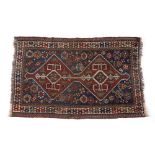 Caucasian blue ground rug with red ground central double medallion, and with stylised foliate
