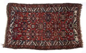 Caucasian red ground rug with foliate medallions and foliate and geometric multiple border, 124cm