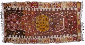 Kelim rug of red ground with five central medallions and with panelled border, 130cm x 240cm