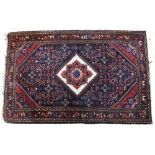 A PERSIAN, BAKTIARI STYLE BLUE AND RED GROUND SMALL RUG with a white diamond central motif on a