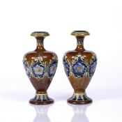 A PAIR OF DOULTON LAMBETH BALUSTER VASES each decorated with a band of flower heads and scrolls,