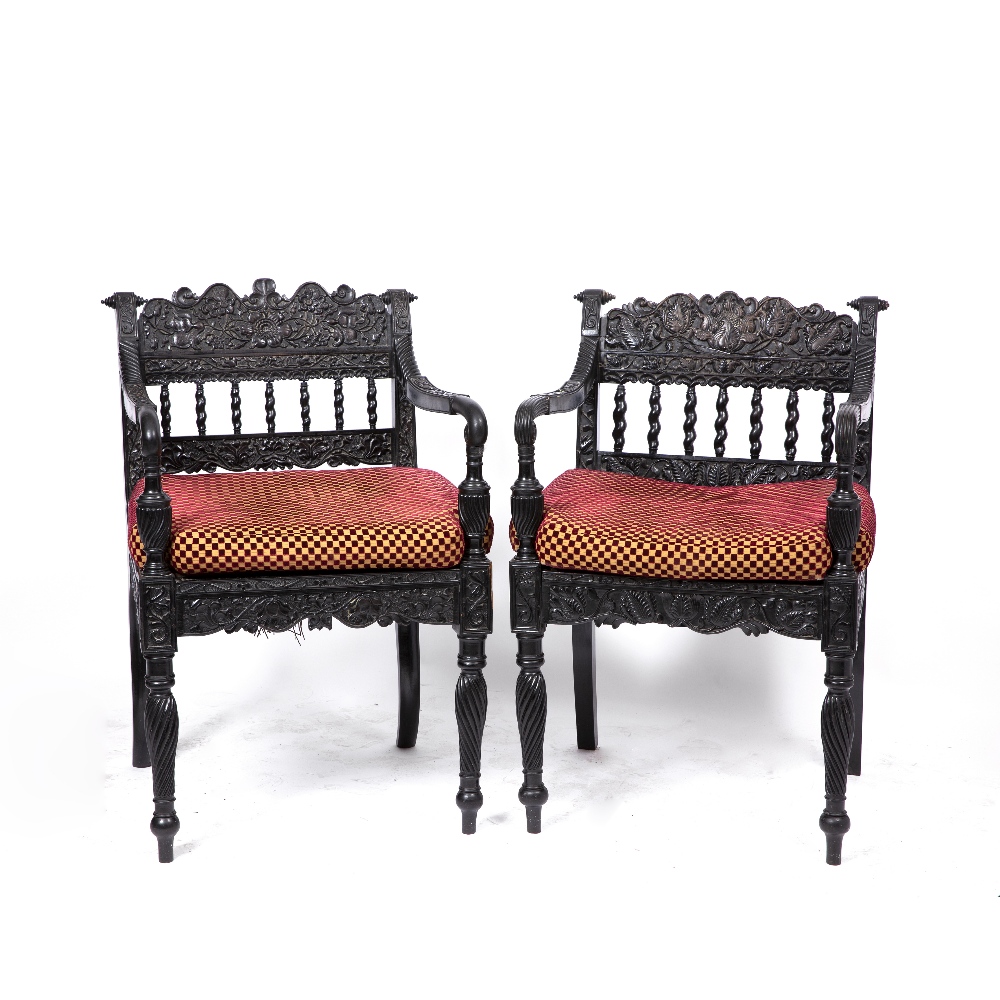 A NEAR PAIR OF EARLY 19TH CENTURY CEYLONESE CARVED EBONY OPEN ARMCHAIRS the foliate crest rails over - Image 7 of 8