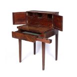 A GEORGE III MAHOGANY WRITING DESK, the raised back with two panelled doors enclosing an arrangement