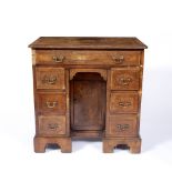 AN 18TH CENTURY WALNUT VENEERED AND FEATHER BANDED KNEEHOLE DESK, fitted with an arrangement of