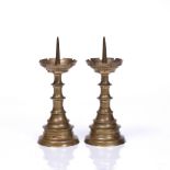 A PAIR OF MINIATURE BRASS PRICKET CANDLESTICKS the castellated drip pans with quatrefoil