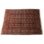 A TEKKE BOKHARA MID RED GROUND TRIBAL RUG decorated three rows of nine elephant foot medallions