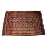 A TEKKE BOKHARA RED GROUND TRIBAL RUG decorated two rows of eight elephant foot medallions with a