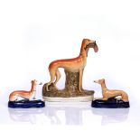 A 19TH CENTURY STAFFORDSHIRE FIGURE of a greyhound with rabbit in his jaws, 28cm high and a pair