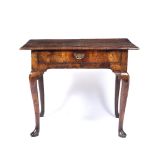AN EARLY 18TH CENTURY WALNUT LOWBOY, the quarter veneered top with feather banded decoration and