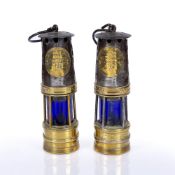 TWO SIMILAR 'HAILWOODS' MINER'S LAMPS, brass and steel with blue glass shades, 26cm high (2)