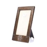 AN ARTS & CRAFTS BEATEN COPPER RECTANGULAR PHOTOGRAPH FRAME bearing the badge for the 74th