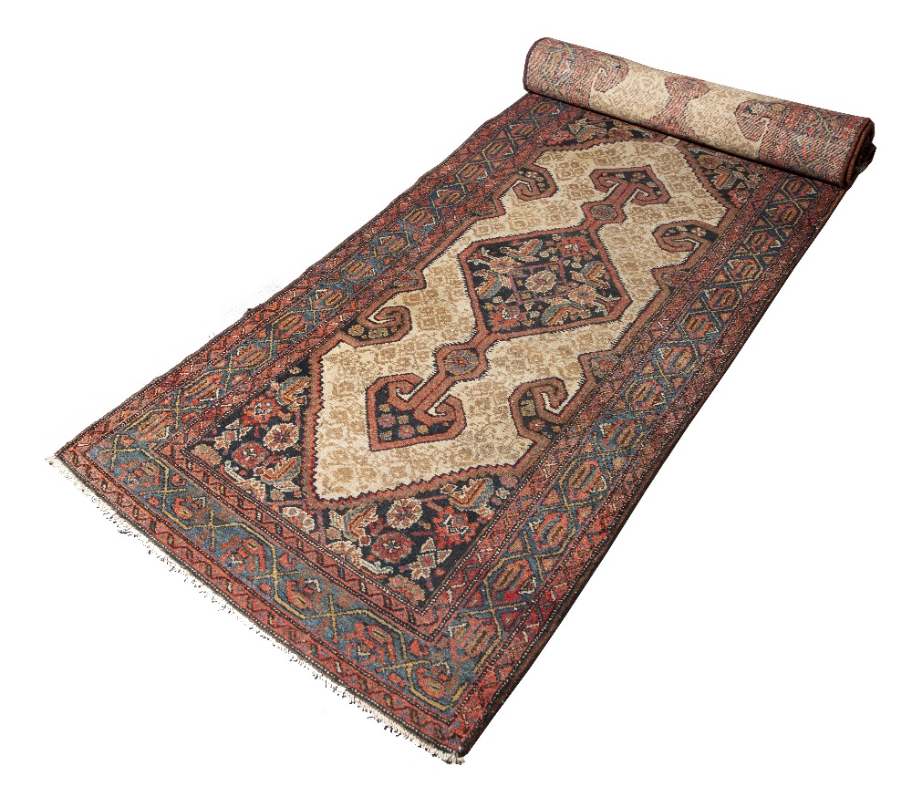 AN OLD PERSIAN HAMADAN LONG RUNNER with an interlocking hooked diamond pattern on a camel ground,